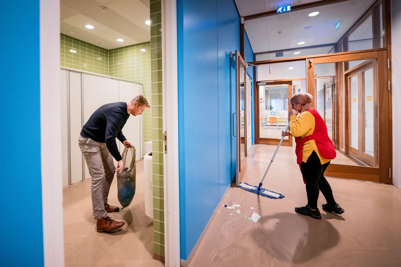 Schoonmakers van schoonmaakbedrijf De Spiegel aan het werk op het Haarlem College in Haarlem. Directeur Sander helpt hier en daar een handje mee.