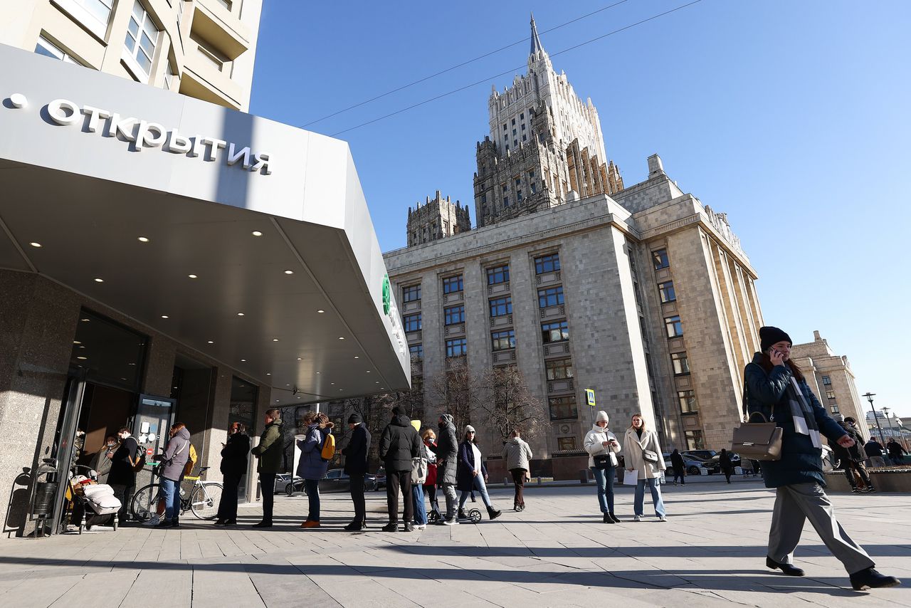 Mensen staan in de rij bij een pinautomaat van de Tinkoff bank in het hartje van Moskou.