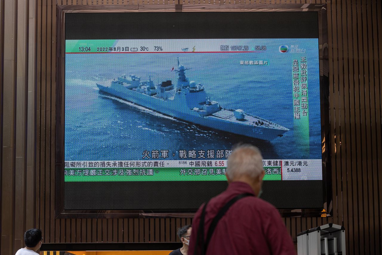 Beelden van een Chinees marineschip op een scherm in een winkelcentrum in Hongkong na het omstreden bezoek van Nancy Pelosi, voorzitter van het Amerikaanse Huis van Afgevaardigden, aan Taiwan. China heeft aangekondigd de komende dagen militaire oefeningen rond het eiland te houden.