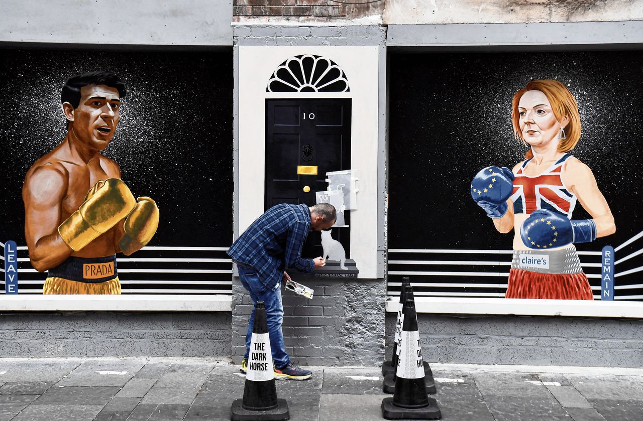 Kunstenaar Ciaran Gallagher legt op 17 augustus de laatste hand aan een muurschildering van de kandidaten voor het leiderschap van de Britse Conservatieven, Rishi Sunak en Liz Truss, in Belfast.