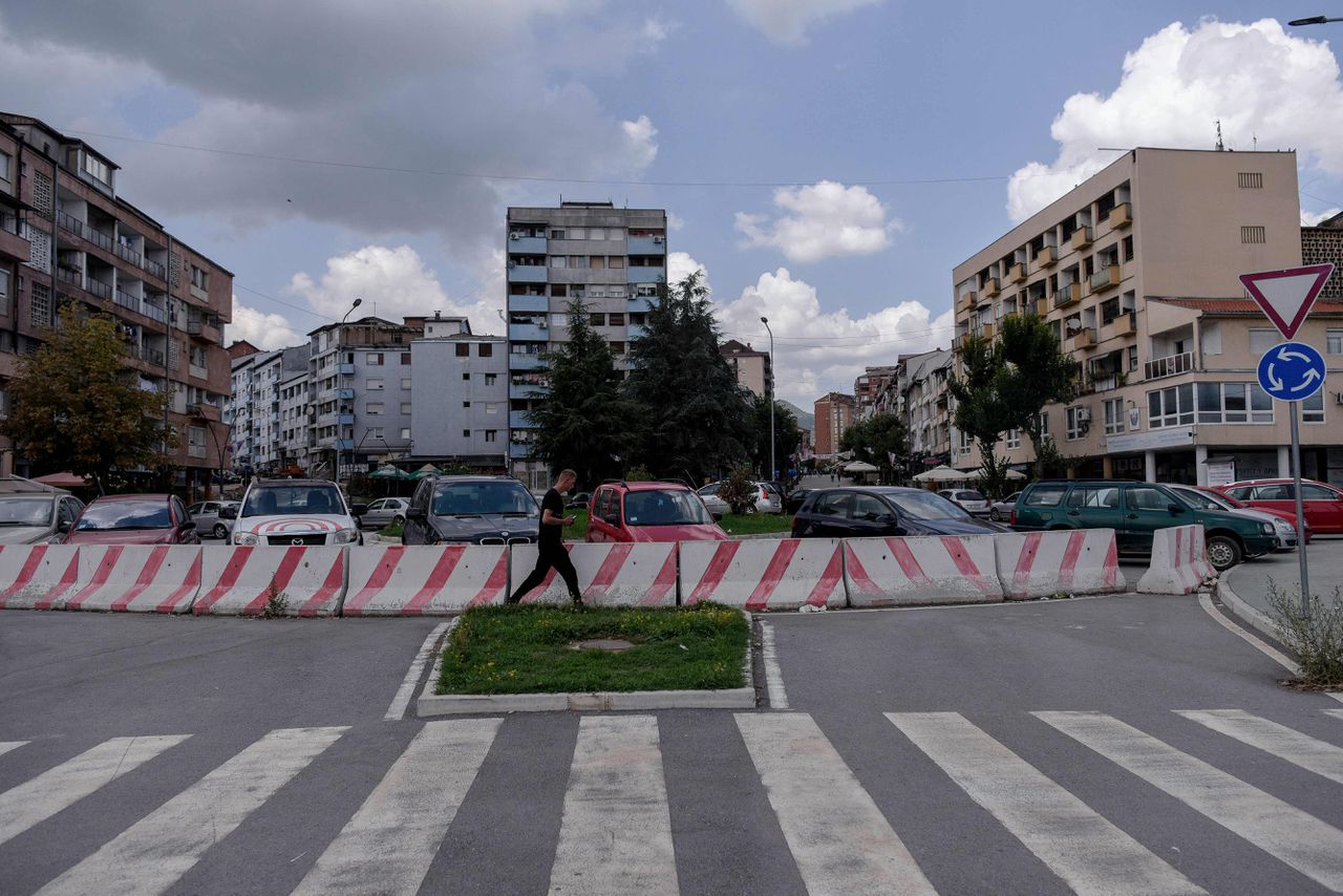 Een man loopt in de Kosovaarse stad Mitrovica, waar de spanningen tussen Kosovaren en Serviërs afgelopen maand hoog opliepen.
