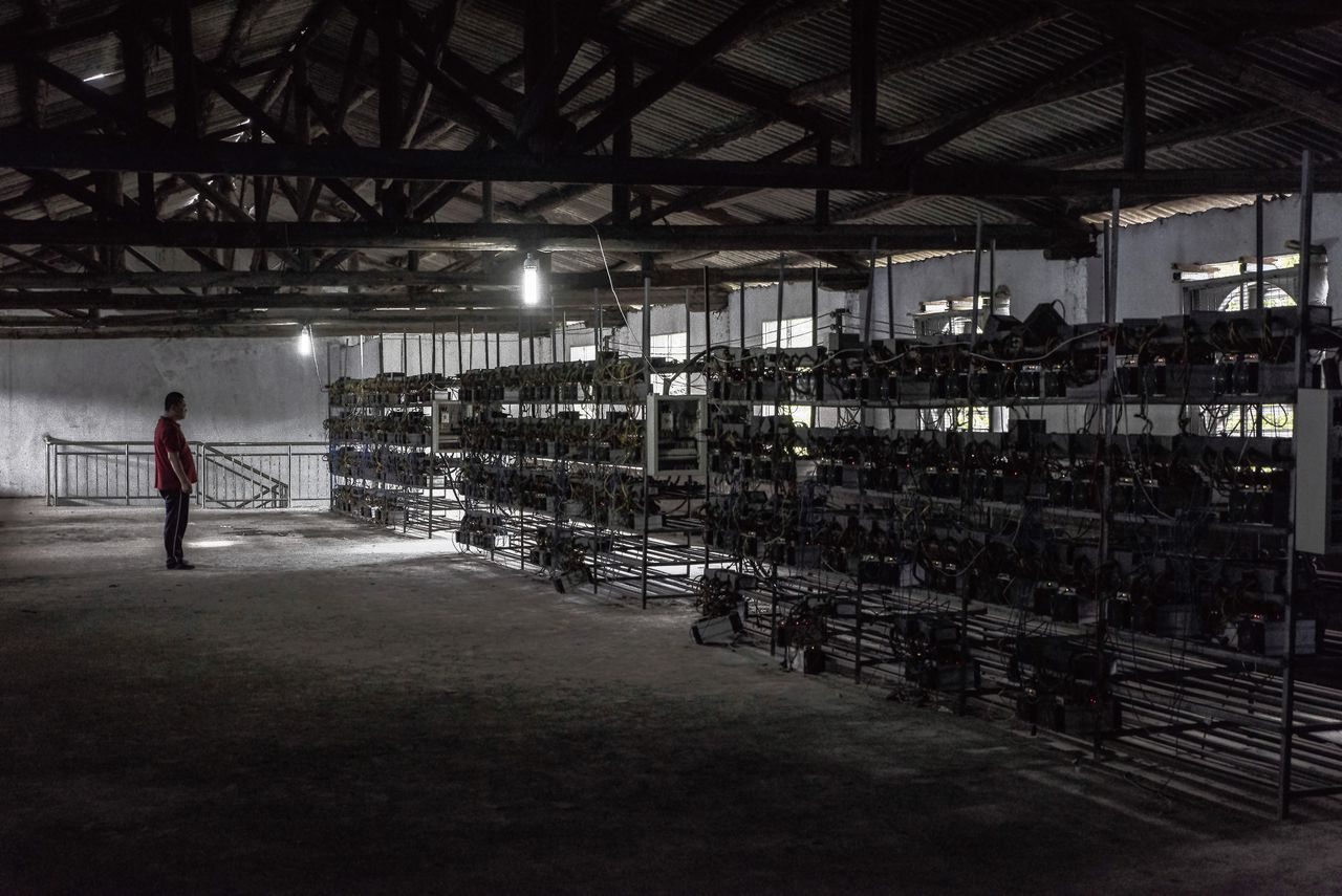 A worker checks bitcoin mining machines at a server farm owned by Peter Ng in Guizhou, China, June 23, 2016. Bitcoin, which is both a new kind of digital money and an unusual financial network, is having something of an identity crisis, coming up against the inevitable push and pull between commercial growth and the purity of its original ambitions. (Gilles Sabrie/The New York Times)