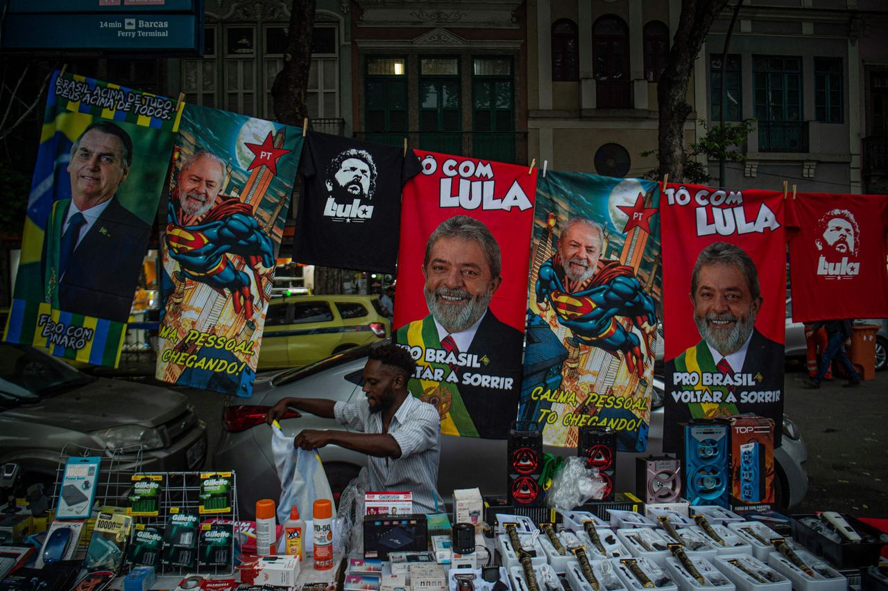 Een marktkoopman in Rio de Janeiro verkoopt badhanddoeken met afbeeldingen van de presidentskandidaten Lula en Bolsanaro. Zondag is de tweede kiesronde.