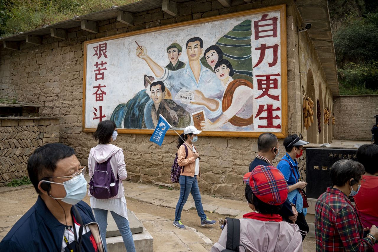 Toeristen bij een muurschildering in het dorp Liangjiahe. Xi woonde er als adolescent.