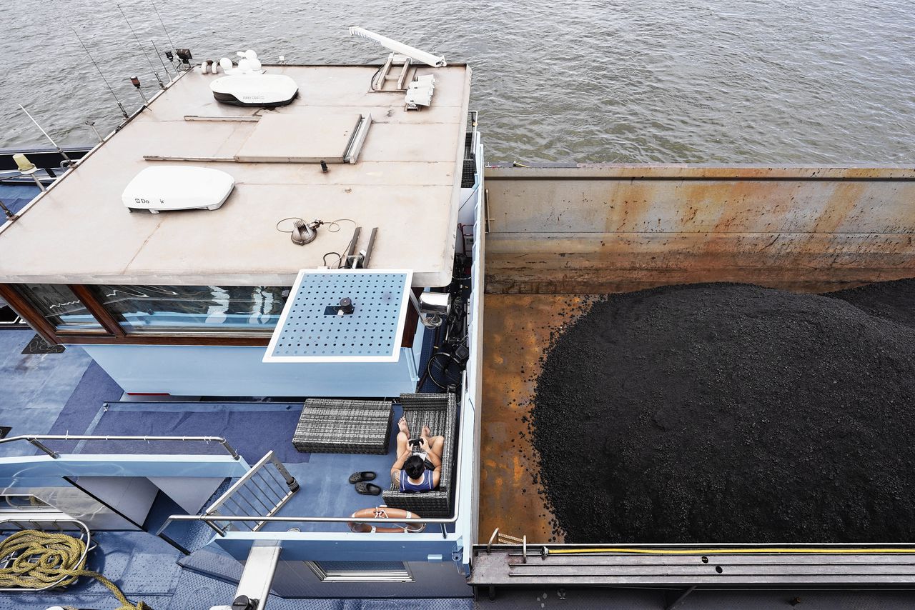 Een binnenvaartschip met kolen wacht voor reparatie aan de kade bij Nijmegen. Door de lage waterstand in de rivieren mochten schepen deze zomer maar een beperkte hoeveelheid vracht innemen.