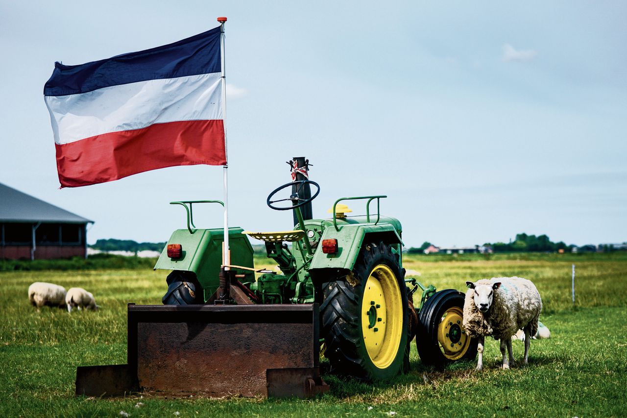 Een omgedraaide Nederlandse vlag, symbool van het boerenprotest tegen het stikstofbeleid, aan een tractor in Waterland.