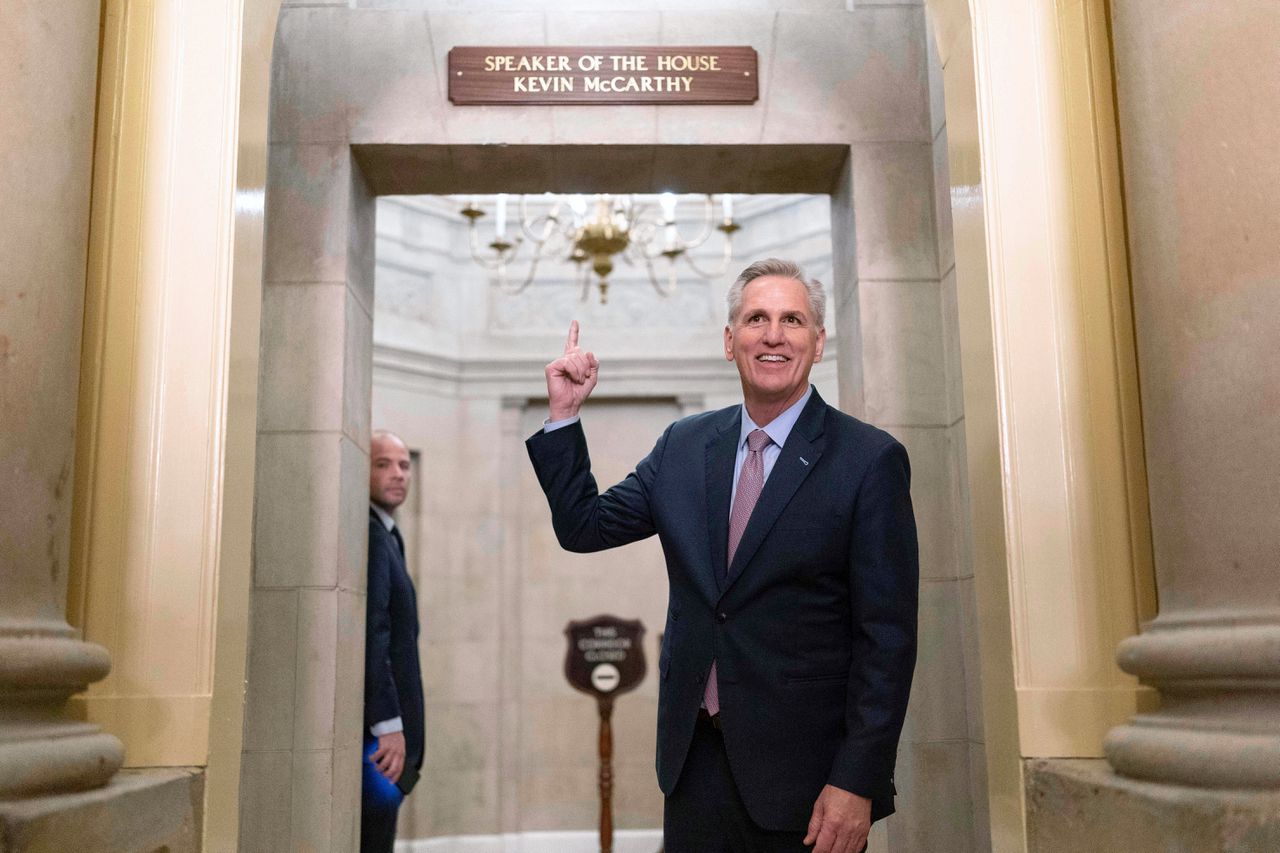 De nieuwe voorzitter van het Huis van Afgevaardigden, de Republikein Kevin McCarthy, wijst zaterdag in het Capitool in Washington naar het naambord bij zijn kantoor.