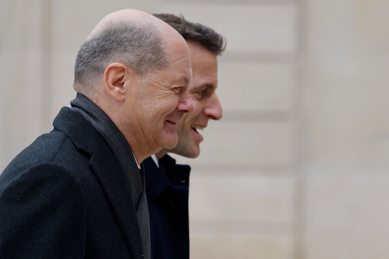 De Duitse bondskanselier Olaf Scholz (voorgrond) en de Franse president Emmanuel Macron komen aan bij een gezamenlijke ministerraad, als deel van de viering van het zestigjarig jubileum van het Élyséeverdrag tussen beide landen, zondag in Parijs.