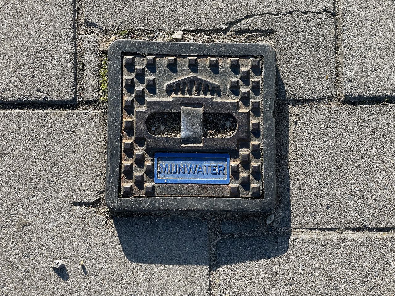 Een putje in een straat in Heerlen waaronder mijnwaterbuizen liggen. Het bedrijf Mijnwater is van plan op termijn dertigduizend aansluitingen te realiseren.