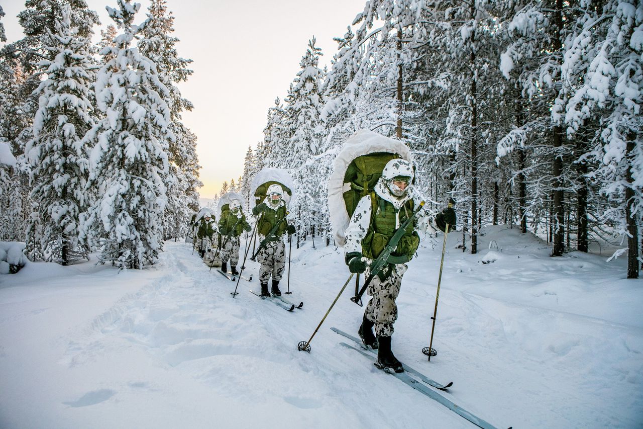 Rekruten van de grenswacht gebruiken langlaufski's tijdens de training in het bos. Ze brengen de nacht buiten door bij temperaturen die dalen tot dertig graden onder nul.