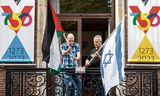 Ambtenaren in Vlaardingen woensdag met de <strong>Palestijnse en Israëlische vlag</strong>. Links de Vredesvlag op het stadhuis.