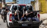 Haïtiaanse politieagenten bewaken in januari in Port-au-Prince de begrafenis van drie collega’s die door gewapende bendes waren omgebracht.
