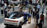 <p>Bezoekers van een grote autobeurs in Shanghai bekijken een elektrische auto van het Chinese merk Xpeng. </p>