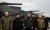 De Poolse premier Mateusz Morawiecki (derde van links) en premier Denys Shmyhal (links) en toenmalig Defensieminister Oleksii Reznikov (tweede van rechts) van Oekraïne bij de levering van de eerste lichting Poolse Leopard 2-tanks aan Oekraïne, februari 2023. 
