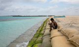 Zandzakken moeten Guraidhoo, een van de Maldiven, beschermen tegen het stijgende zeewater. Het is de vraag of de kleine eilandstaten een temperatuurstijging van meer dan anderhalve graad overleven. 