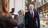 Een vrouw poseert woensdag op straat in Moskou bij een kartonnen versie van <strong>president en presidentskandidaat Vladimir Poetin</strong>.
