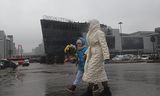 Mensen lopen zondag met bloemen langs het zalencomplex Crocus City Hall in de Moskouse voorstad Krasnogorsk, om hun medeleven te betuigen met slachtoffers van de terreuraanslag van vrijdag. 