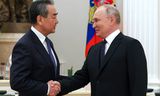De Russische president Poetin (rechts) begroet Wang Yi, de hoogste Chinese ambtenaar verantwoordelijk voor het buitenlands beleid, woensdag tijdens diens bezoek aan Moskou.